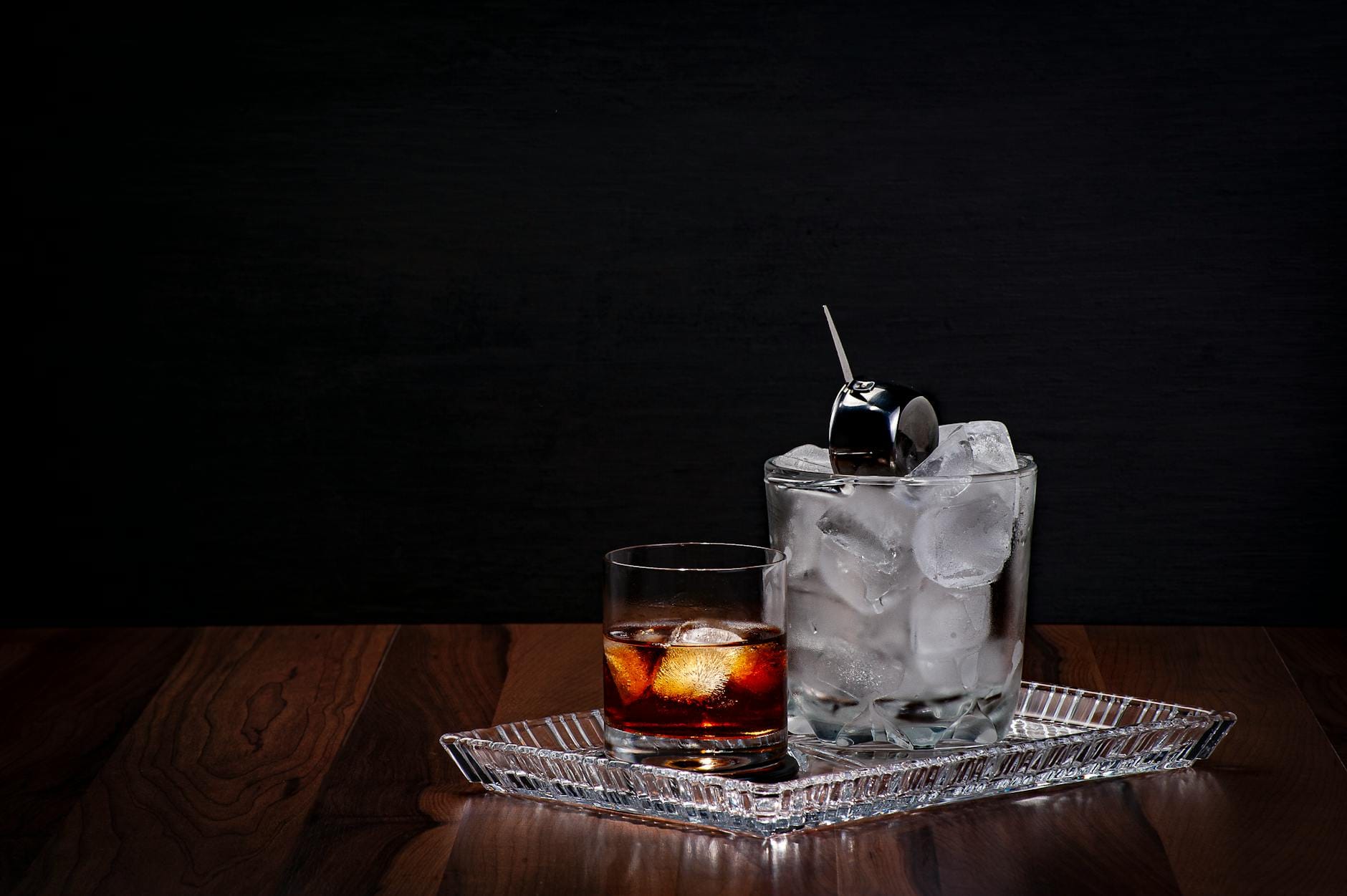 Szklanka whisky z lodem na drewnianym stole, zbliżenie