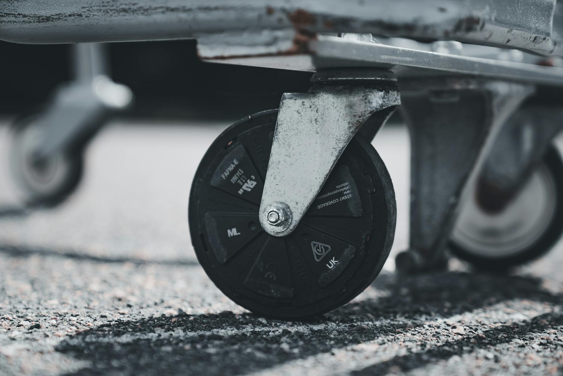 Zbliżenie na kółko wózka sklepowego na tle miejskiego chodnika